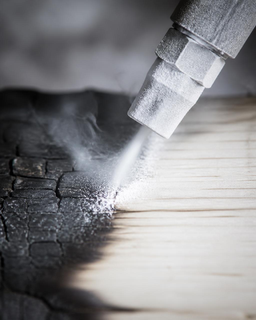 Dry ice blasting nozzle cleaning charred wood to pristine white
